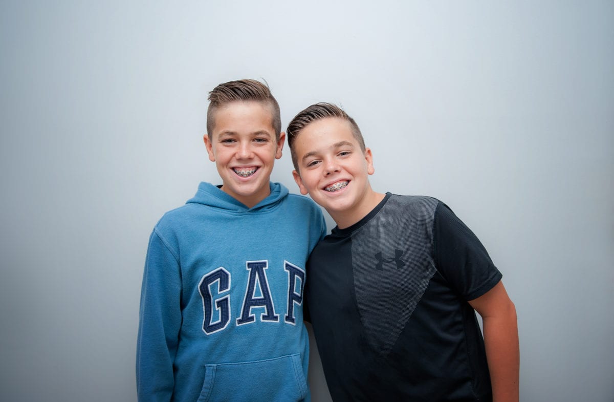 Two smiling young patients with braces